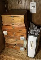 Stacked binder and five wooden cigar boxes on shelf