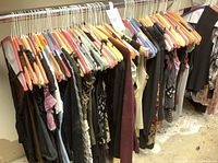 Rack of assorted size small women's garments on hangers showing various colors and styles