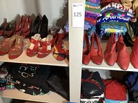 Shelves showing multiple pairs of red women's leather shoes and stacks of folded printed vacation T-shirts.