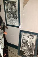 View of two framed promotional posters leaning against a wall, showing the Tenspeed and Brownshoe poster on the left and the Wiseguy poster on the right.