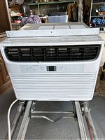 Front view of white Frigidaire window AC unit showing black vents and control panel with digital display.