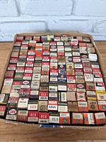 Top-down photo showing multiple rows of boxed vacuum tubes with a variety of vintage brand logos and model numbers.