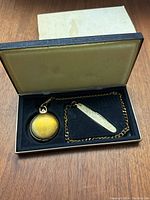 Gold-toned pocket watch and pocket knife with chain inside box