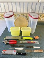 Full arrangement of all kitchen items including containers and utensils on a kitchen counter with floral wallpaper background