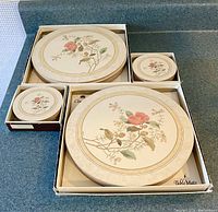 Boxed set of 6 round floral table mats with 6 coasters, showing floral design and cork bottoms