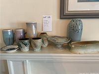 All ten pottery pieces on mantel shelf: dish, mugs, vases, cups, compote, planter