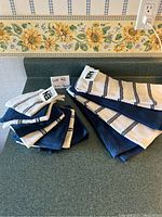 Blue and white dish towels folded and laid out on counter, showing multiple pieces with tags.