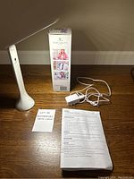 Smart Lamp R10 assembled and standing on wooden table, box, power adapter, manual, and lot note.