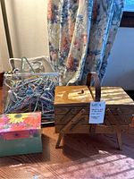 Wooden sewing box with floral card box and clear container of hangers all arranged on wood floor