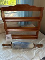 Full view of wooden spice rack and ceramic rolling pin showing overall condition and structure.