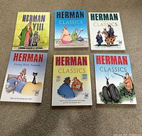 Flat lay photo showing all 6 soft cover Herman cartoon books arranged on floor, covers facing up.