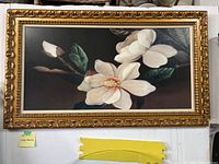 Full view of large framed magnolia flower artwork with visible dark background and white flowers.