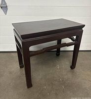 Single dark-finished Oriental style solid wood side table showing rectangular top and bracket cross support detail on legs.