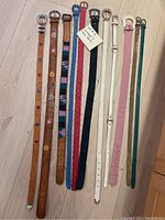 Photo showing all 10 belts laid out on floor, highlighting various colors, patterns and buckle styles.