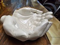 Side angle showing the sculptural detail and gold accent on the wrist area of the Jesmonite hand bowl