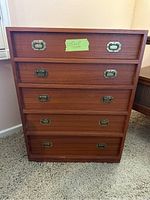 Front view of the mid-century teak jewelry chest showing five drawers and brass hardware