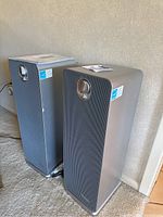 Two Guardian Technologies 3 in 1 air cleaners shown side by side on carpeted floor.