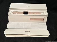 Apple Watch Series 3 in pink color with original packaging, showing watch inside box with one band attached and another band separate.