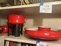 Shelf view showing red fondue pot on stand and serving tray