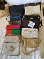 Group shot of all eleven purses laid out on bed