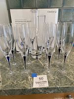 Group of eight Intermezzo Blue flutes and carafe displayed with original Orrefors box