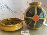 Wide shot of ashtray and vase side by side on gray table with marble-patterned backdrop