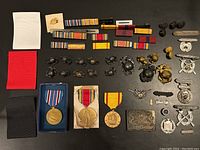 Overview of all lot items including medals, ribbons, pins, insignia, and buckles