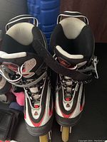 Pair of men's size 10 Cooper rollerblades in black, white, and red with laces and ankle straps