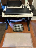 Full view of office ergonomic setup with keyboard and mouse platform, laptop platform, footrest, and floor mat under a desk frame.