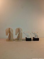 Two pairs of horse bookends displayed side by side, showing onyx pair with slight chips and marble pair on black bases.