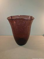 Purple crackle glass vase, irregular wavy flared rim, shown from side angle.