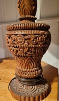 Close-up of detailed hand-carved floral and geometric pattern on wooden lamp base