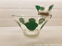 Photo of the chip and dip bowls showing the large bowl with green leaf patterns and the smaller dip bowl held by gold metal holder.