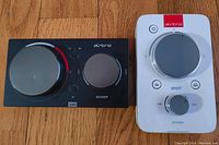 Front view of two Astro MixAmp gaming audio amplifiers showing main volume and control knobs.