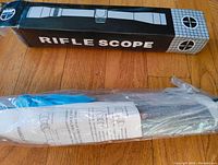 Box labeled 'Rifle Scope' with schematic drawing, showing original packaging.