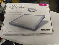 Box of Artograph LightPad LED light table showing product image and details, size 9 x 12 inches.