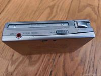 Top view showing microphone input, hold switch, play/pause button, and eject button with the dent visible on the front side.