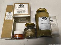 Photo showing Origins Plantscriptions Youth-Renewing Power Night Cream, Anti-Aging Treatment Lotion, small jars including an orange one, and Origins Checks and Balances Frothy Face Wash.