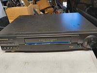 Front view of Panasonic VCR showing the tape slot and unit top surface with minor wear.