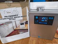 Ionizer unit next to original box showing label and unit display