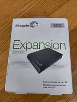 Front view of Seagate Expansion hard drive retail box showing branding, product image, and 1.5TB USB 3.0 storage specification.