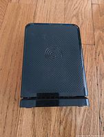 Seagate external hard drive top view showing textured black surface with Seagate logo, sitting on wood floor.
