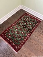 Rug laid out diagonally, showing full length, colors, and fringes at one end.