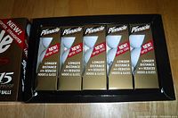 Photo showing five individual boxes of Pinnacle Gold LS golf balls arranged in a display box.