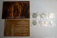 Original packaging and certificate sheet of the 2004 Canadian proof-like uncirculated coin set along with sealed coins in a plastic sleeve.
