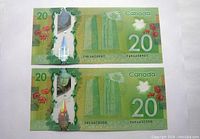 Photo showing front of two Canadian $20 polymer bills placed side by side.