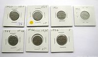 Seven Canadian nickels dated 1927, 1929, 1931, 1932, 1934, 1935, 1936 in white holders with handwritten years and grading notes.