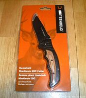 Front view of Huntshield MacKenzie EDC Folder knife in original packaging showing blade and handle design.