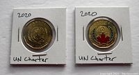 Front side of two 2020 Canadian UN Charter Loonies, one plain and the other colored with red and blue accents.