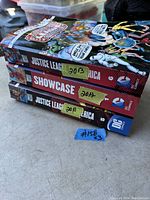 Stacked view of three DC Showcase comic books showing spine with years 2011, 2012, 2013 and Justice League of America title.